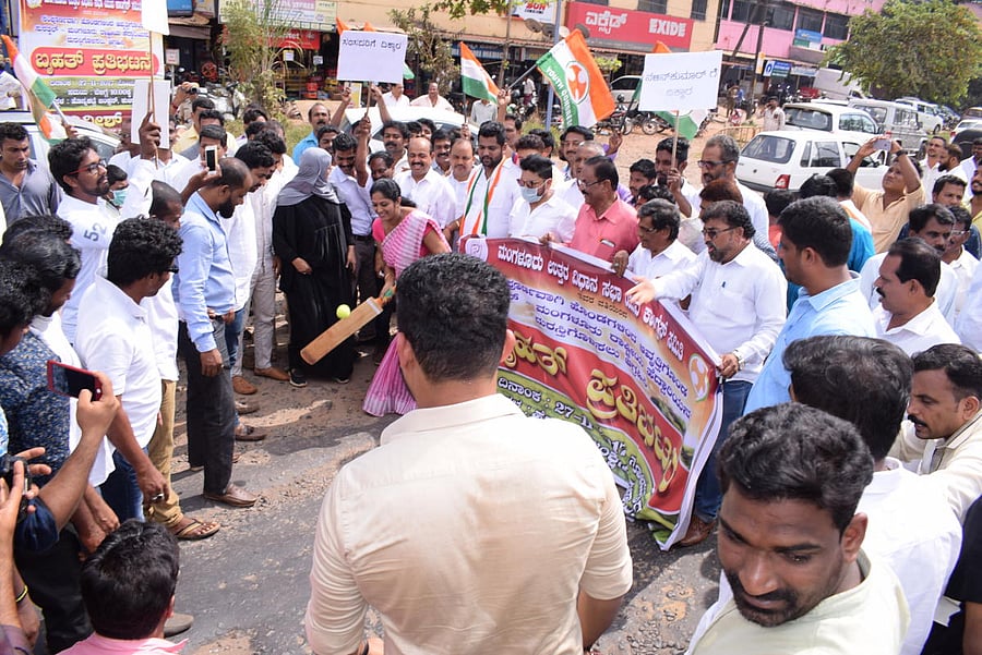 Corporator and Women Congress secretary Prathibha Kulai plays cricket in protest against the pathetic condition of NH 66 on Monday.