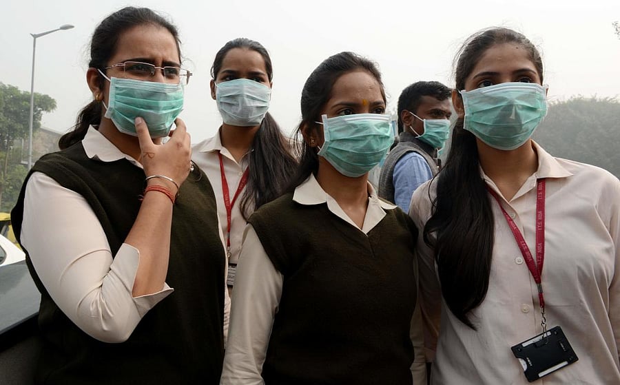 Girls protect themselves from pollution with face masks in New Delhi. AFP File