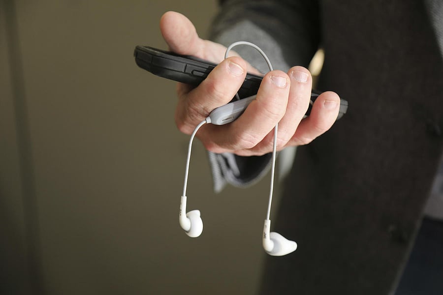Cade Metz, a technology reporter for The New York Times, with his Android phone and ear buds, in San Francisco, Dec. 7, 2017. Metz keeps a close eye on digital assistants as a way of keeping tabs on artificial intelligence trends.