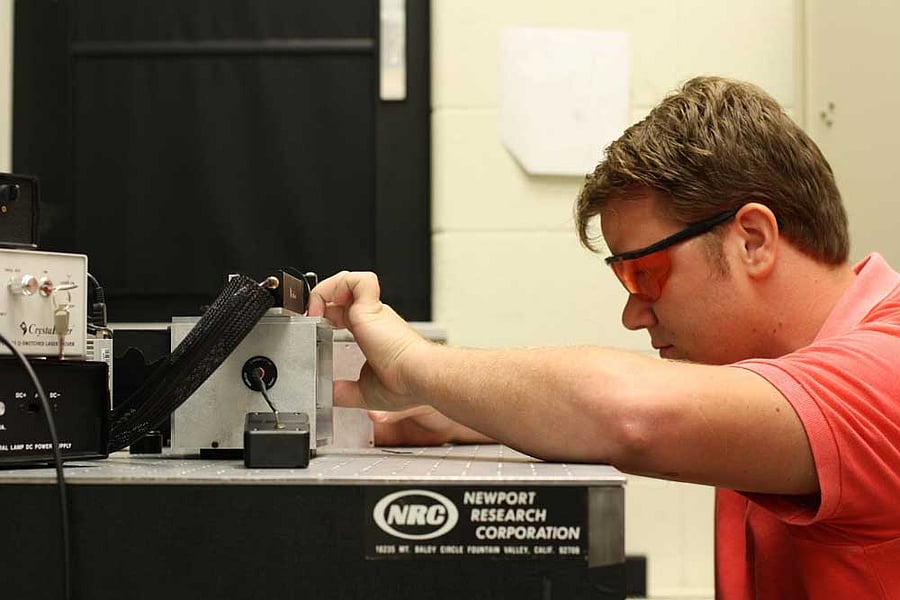 A researcher works on the standoff ultra-compact micro Raman instrument, built to help find life on other planets. Photo: M. Nurul Abedin, NASA Langley Reserach center.