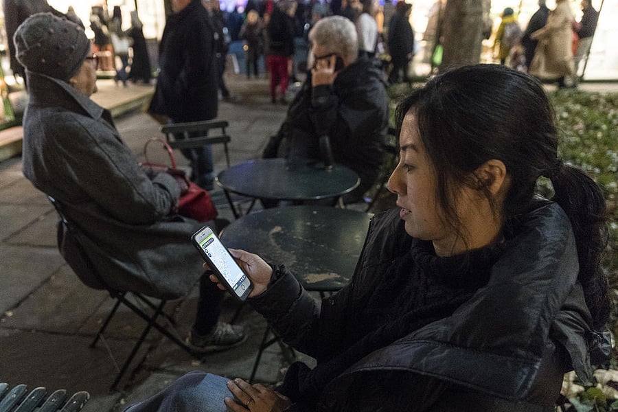 Hiroko Tabuchi, an environmental reporter for The New York Times, uses the Haze Today app in New York, Dec. 18, 2017. The Haze Today app tracks the air quality index of locations around the world in real time. (Jeenah Moon/The New York Times)