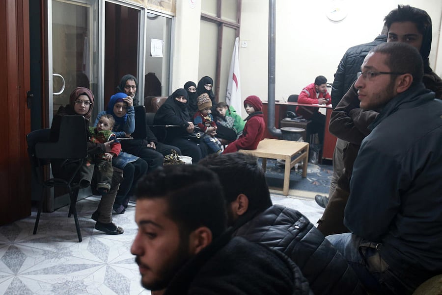 Civilians wait during an evacuation operation by the International Committee of the Red Cross in Douma in the eastern Ghouta region on the outskirts of the Damascus, Syria. AFP