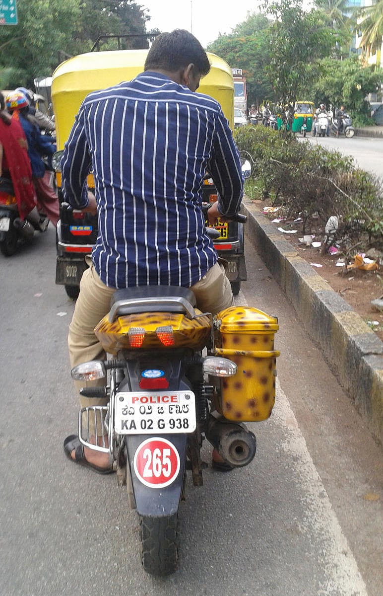 A day before the traffic police's ambitious initiative Compulsory Helmet Campaign' in City, a policeman was spotted riding the official bike without wearing a helmet near Aralimara Junction on Chord Road near Toll Gate Magadi Road. DH Photo by Jagadish Angadi.The police will not spare their colleagues while enforcing the helmet rule.