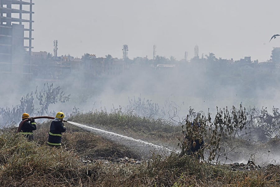 Fire men spray water to extinguish a fire broken out from the Bellandur lake which caught fire, in Bengaluru on Saturday. Photo by S K Dinesh