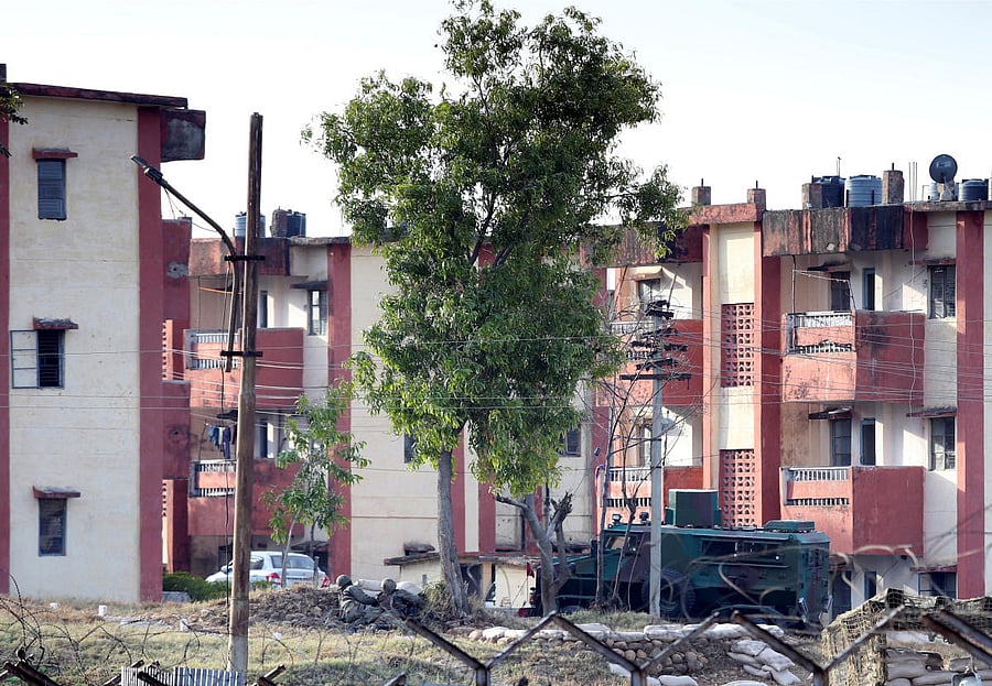 Indian army soldiers take their positions as an armoured vehicle moves inside an army camp after suspected militants attacked the camp on Saturday, in Jammu
