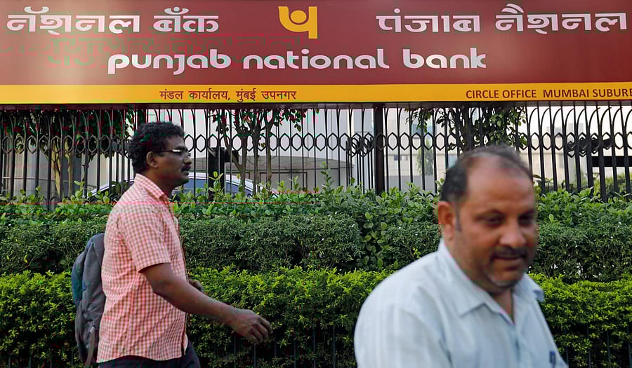 Pedestrians walk past a Punjab National Bank office in Mumbai, Indi aFebruary 21, 2018. REUTERS/Danish Siddiqui