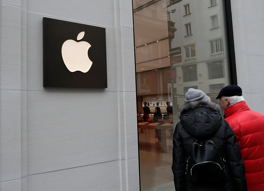 People look into a shop window of Austria's first Apple store, which opens on February 24, during a media preview in Vienna, Austria, February 22, 2018. REUTERS/Heinz-Peter Bader
