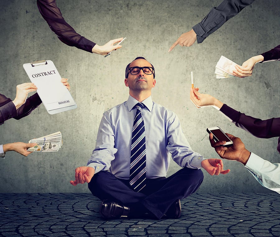 A man meditating to relieve the stress of busy corporate life.