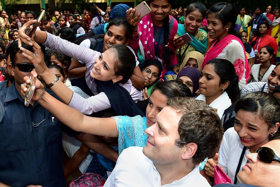 Students of Maharani Arts, Science and Commerce College takes selfie with Congress President Rahul Gandhi, during his Janashirvada Yatra in Mysuru on Saturday. PTI Photo
