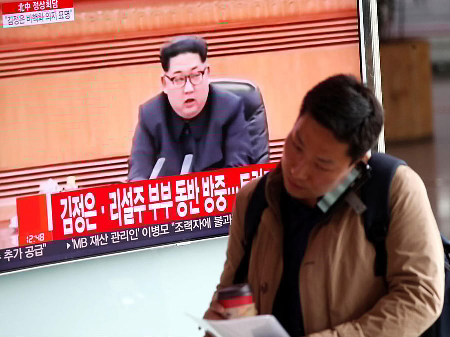 A man walks past a TV broadcasting a news report on a meeting between North Korean leader Kim Jong Un and Chinese President Xi Jinping in Beijing, in Seoul, South Korea, March 28, 2018. Reuters.