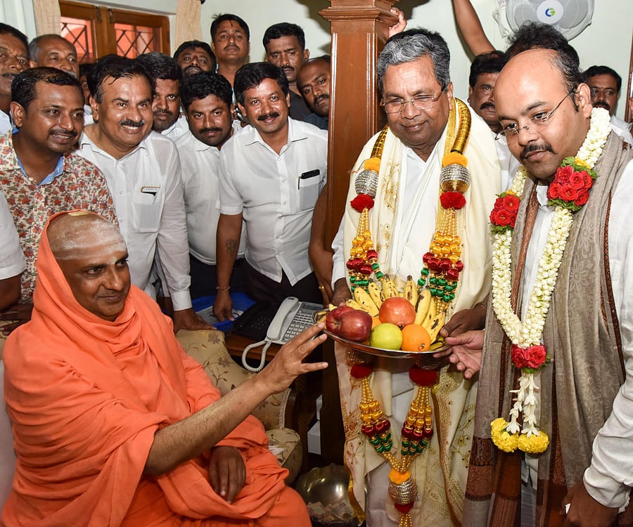 Chief Minister Siddaramaih and his son Yateendra taking blessing from Suttur Mahasamsthana Math Seer Shivarathri Deshikendra Swamiji during visited the Suttur Math in Mysuru on Friday. -Photo by Savitha. B R