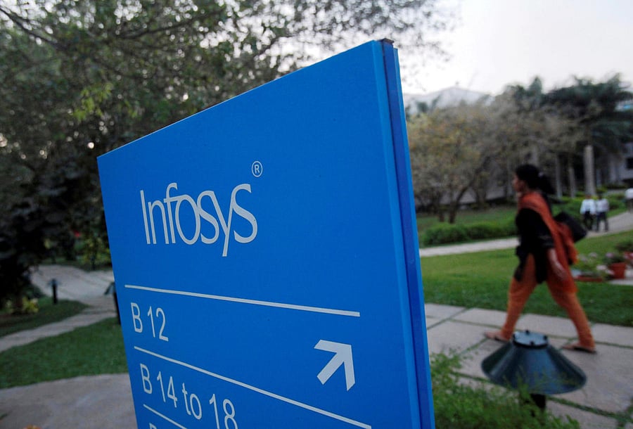 FILE PHOTO: An employee walks past a signage board in the Infosys campus at the Electronics City IT district in Bangalore, February 28, 2012. REUTERS/Vivek Prakash/File Photo GLOBAL BUSINESS WEEK AHEAD