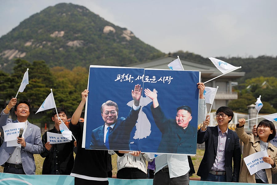 Students hold posters with pictures of South Korea's President Moon Jae-in and North Korea's leader Kim Jong Un during a pro-unification rally ahead of the upcoming summit between North and South Korea in Seoul, South Korea April 26, 2018.