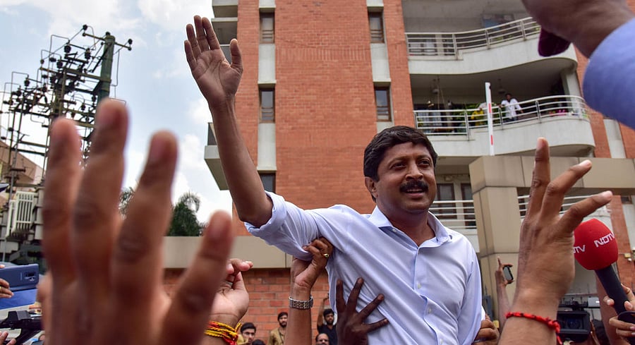 Congress candidate from Hebbal, Byrathi Suresh, takes part in a protest against his JD(S) and BJP rivals during the re-polling in Lottegollahalli on Monday. DH PHOTO/B H Shivakumar