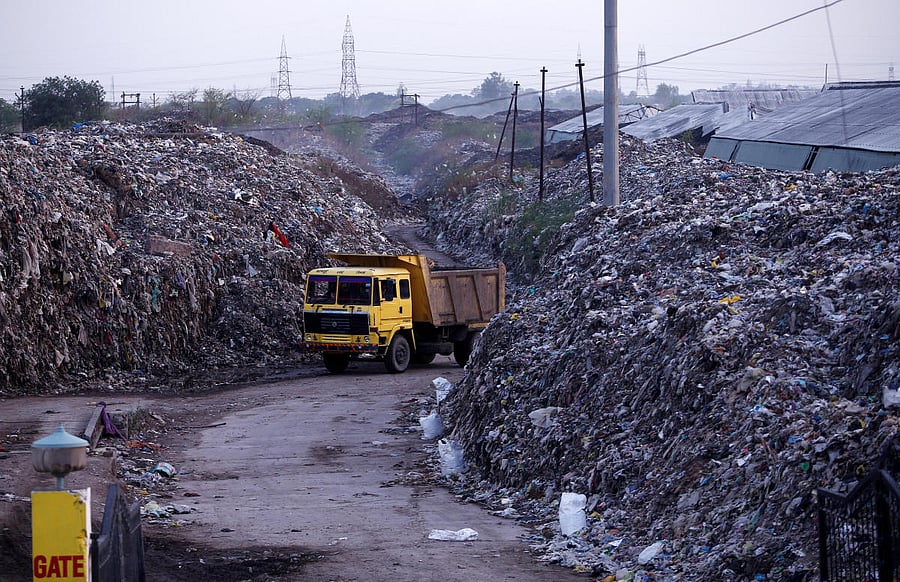 Smoke billows as a truck drives past the waste of leather tanneries at a dumpyard in Kanpur. REUTERS