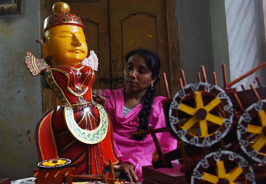 A girl busy gives final touches to a toy in Kondapalli. AFP
