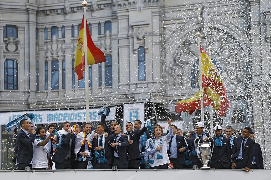 Real Madrid players celebrate with the trophy in Cibeles square in Madrid on Sunday. PTI