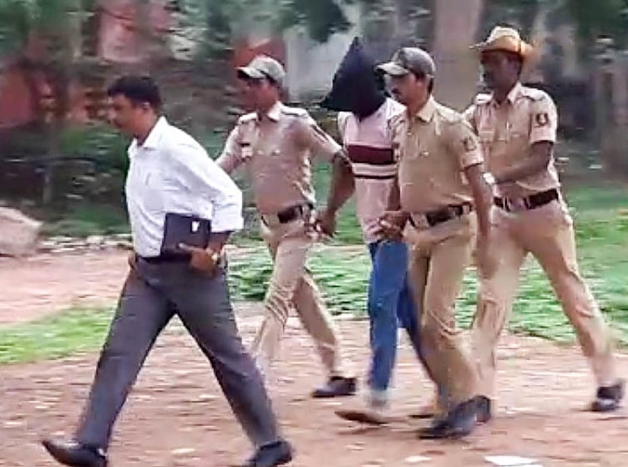 Officials of the Special Investigation Team escort one of the accused in the Gauri Lankesh murder case.
