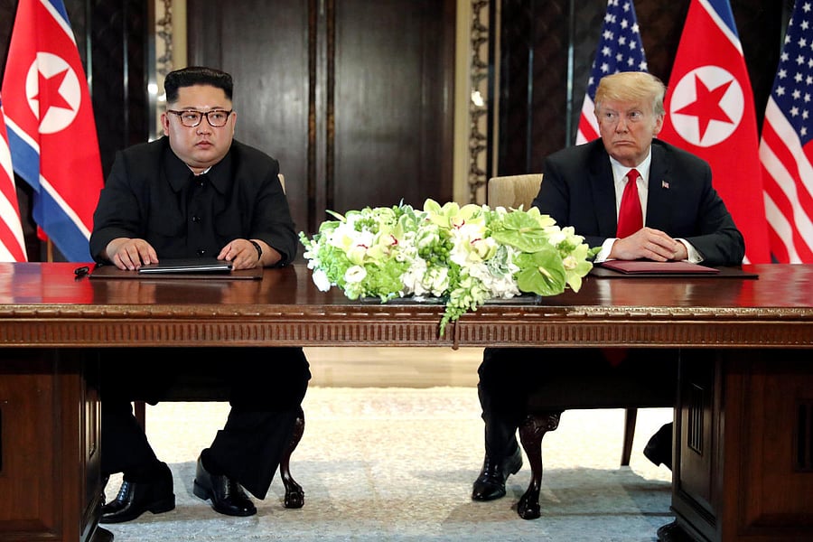 US President Donald Trump and North Korea's leader Kim Jong Un hold a signing ceremony at the conclusion of their summit at the Capella Hotel on the resort island of Sentosa, Singapore. Reuters photo.