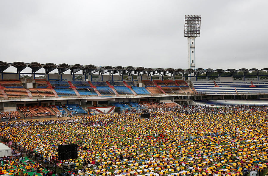 Participants perform yoga at Kanteerava stadium on International Yoga Day in Bengaluru on Thursday. (Reuters Photo)