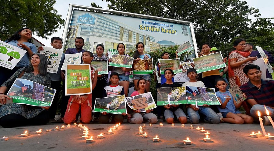 Activists from various environmental organisations during a candle light vigil against cutting of trees in Nauroji Nagar area, in New Delhi. PTI photo.