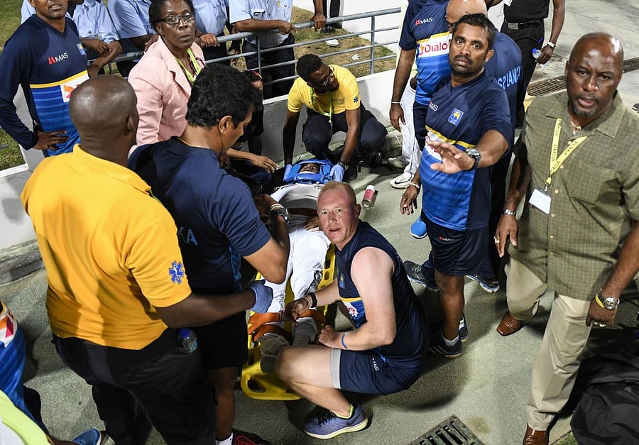 CONCERNED Sri Lanka's Kusal Perera is surrounded by medical personnel after injuring his shoulder while fielding on Monday. AFP