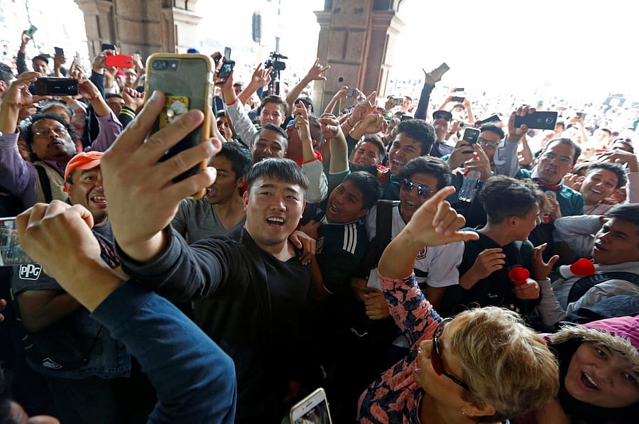 Mexican soccer fans celebrate with a South Korean citizen, in Mexico City. (Reuters Photo)