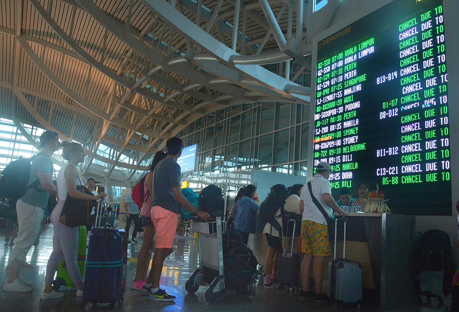 Passengers stand in front of a flight board after services were cancelled due to Mount Agung eruption at Ngurah Rai Airpot, in Bali, Indonesia, on Friday. (Reuters)