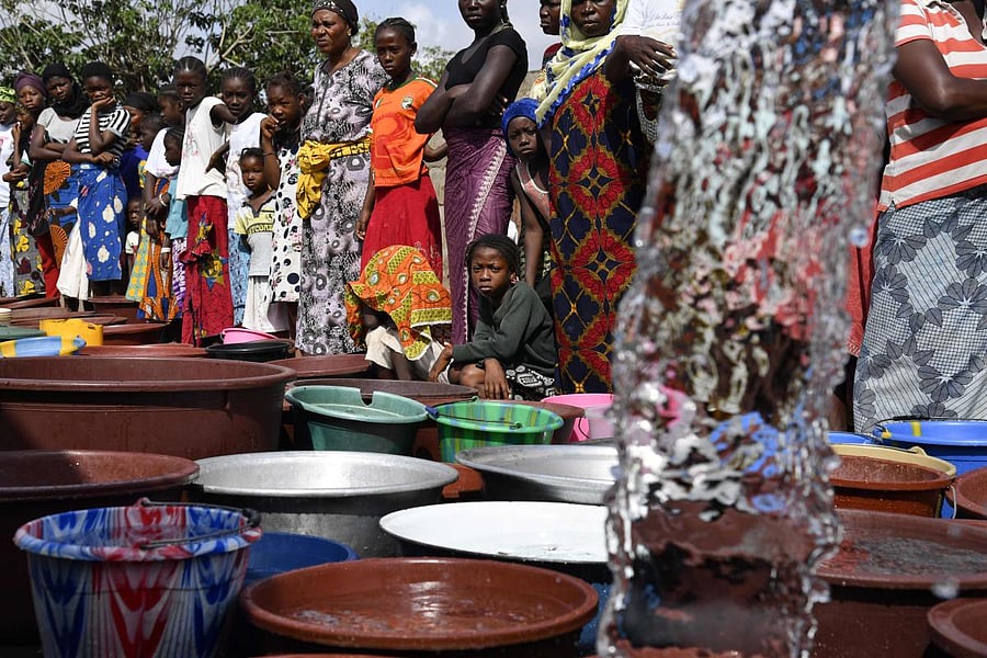 A worker of the National Office of Drinking Water (ONEP) distributes water to the population on June 2, 2018 in a district of Bouake, central Ivory Coast, where the largest dam of the "Societe de Distribution de l'Eau de la Cote d'Ivoire" (SODECI - Water