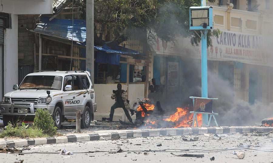 A Somali military officer carries his gun as he secures the scene of a suicide car bombing near Somalia's presidential palace in Mogadishu, Somalia July 7, 2018. REUTERS/Feisal Omar