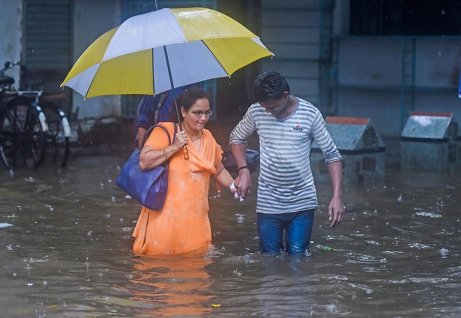 People make their way through flooded waters after heavy downpour at King Circle in Mumbai on Tuesday. PTI