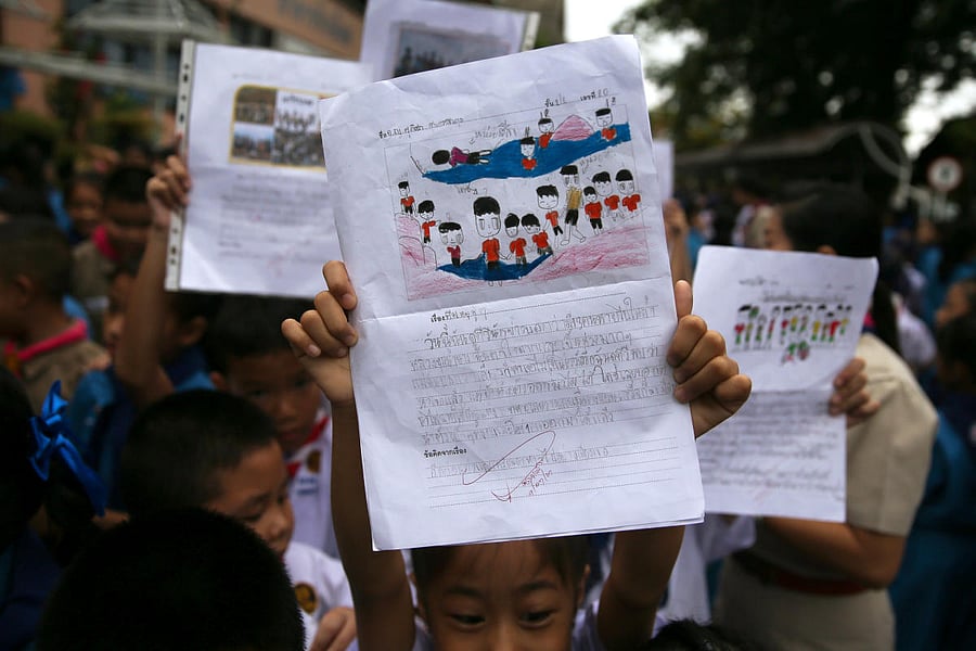 Students celebrate in front of Chiang Rai Prachanukroh hospital, where the 12 soccer players and their coach rescued from the Tham Luang cave complex are being treated, in the northern province of Chiang Rai, Thailand, July 11, 2018. (REUTERS/Athit Perawo