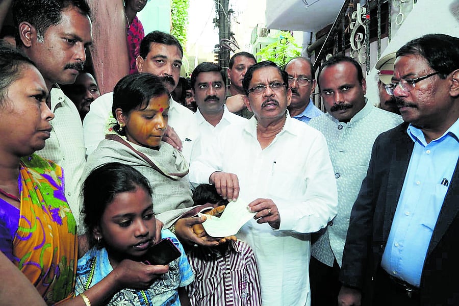 Deputy Chief Minister G Parameshwara hands over Rs 5 lakh compensation to the family of Subramani S, the pourakarmika who committed suicide for not paying salary for months, on Sunday. (DH Photo)