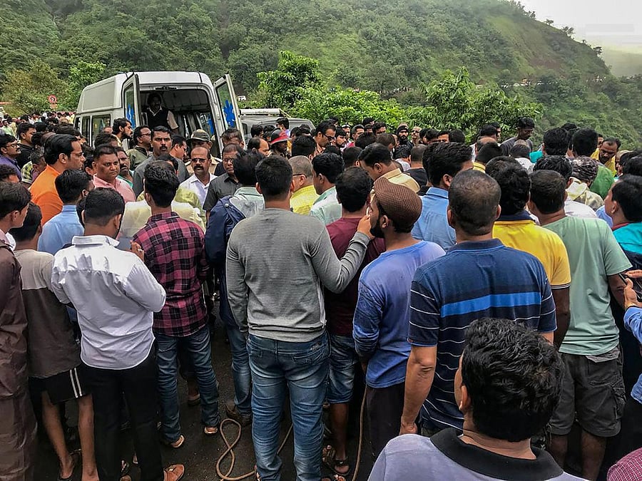 Tragedy: People gather at the site where a bus fell into a gorge in the Konkan region, killing 33 on Saturday. PTI