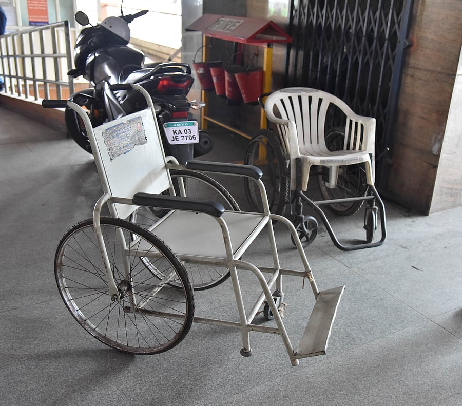 Both wheelchairs at Shivajinagar are broken. One has a missing wheel, while the other is a plastic chair mounted on a rusty frame.