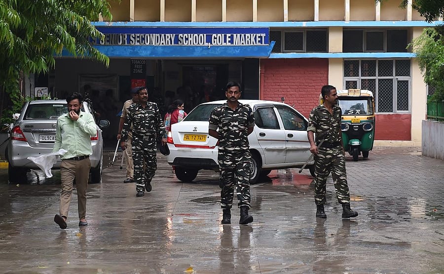 Indian security forces walk inside the government school where a seven years old girl student was sexually assaulted, in New Delhi on August 10, 2018. - Scores of angry parents protested outside a government-run school in New Delhi on August 10 after a se