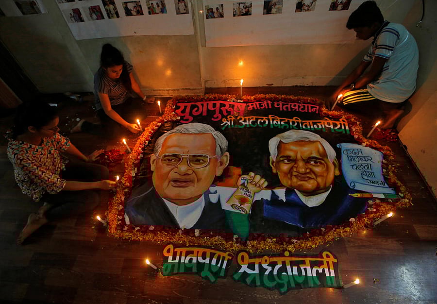 Students place candles around a painting featuring India's former prime minister Atal Bihari Vajpayee to pay him homage in Mumbai, India, August 16, 2018. (REUTERS)