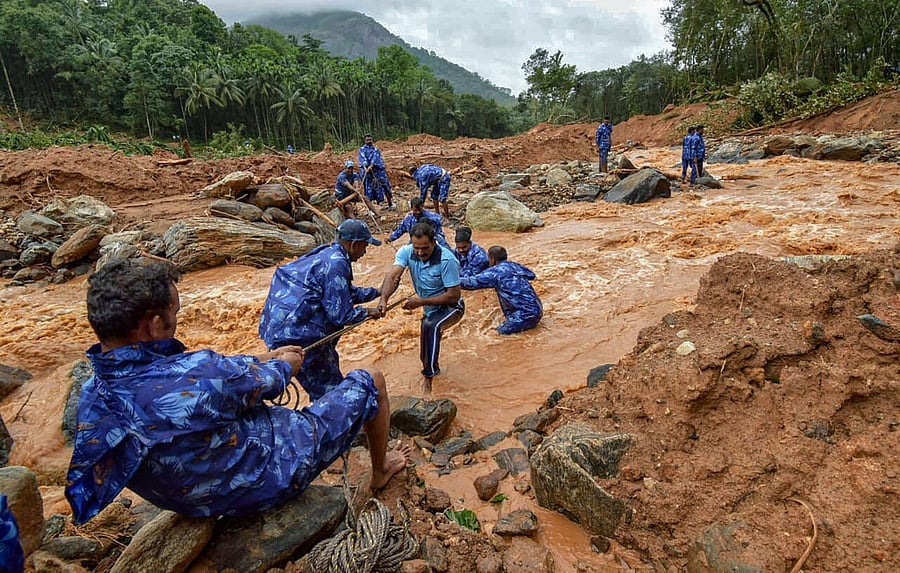 Rescue workers search for the bodies of missing persons after a landslide, triggered by heavy rains and floods, at Nenmara in Palakkad on Friday. PTI