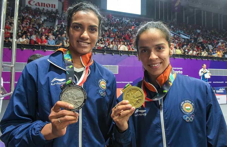 GOOD SHOW: Indian silver medalist PV Sindhu (left) and Saina Nehwal with her bronze medal in Jakarta, Indonesia on Tuesday. (PTI Photo)