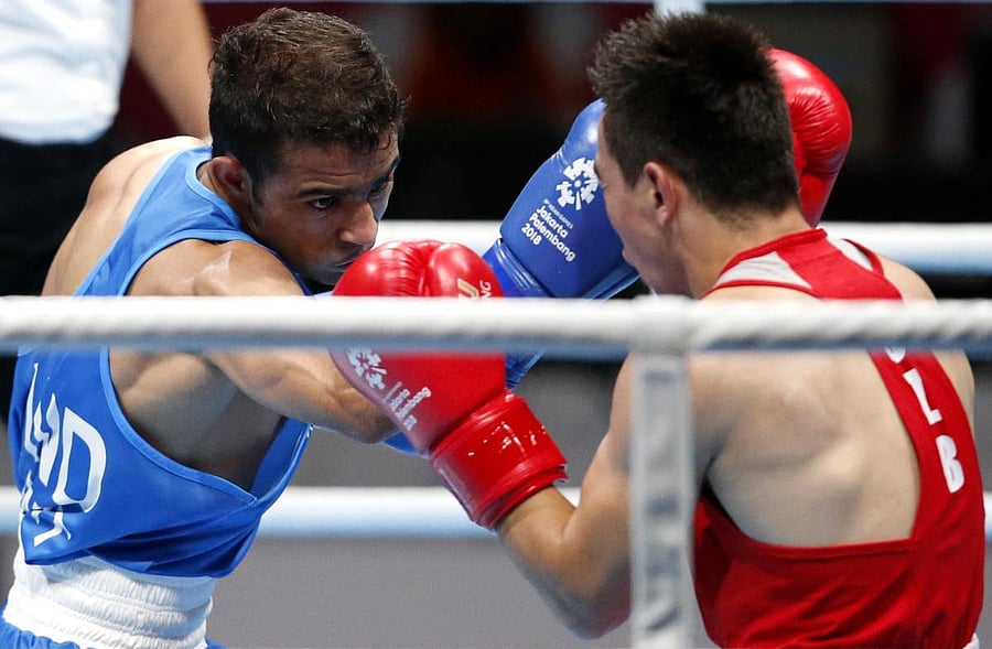 India's Amit Panghal (left) and Hasanboy Dusmatov of Uzbekistan fight it out in the final of the Men's Light Fly in Jakarta on Saturday. REUTERS