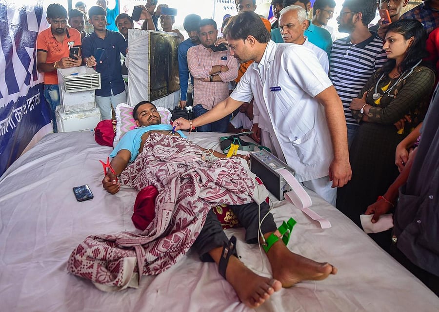 A doctor checks the health of Patidar Anamat Andolan Samiti (PAAS) leader Hardik Patel on the 7th day of his indefinite hunger strike for reservation, in Ahmedabad on Friday, Aug 31, 2018. (PTI Photo)