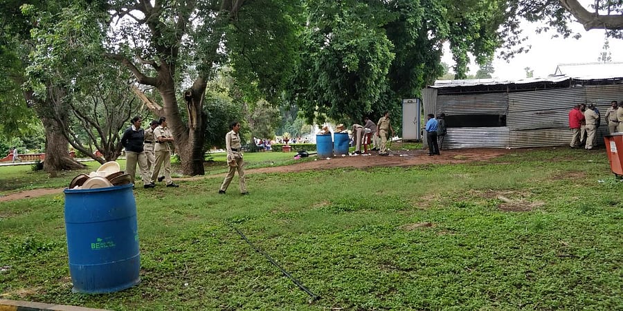 Policemen throw paper plates into already overflowing bins.