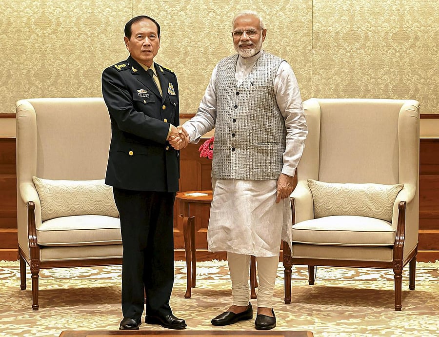 Prime Minister Narendra Modi shakes hands with Defence Minister of China, General Wei Fenghe during a meeting in New Delhi on Tuesday. PTI Photo
