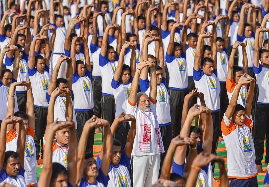 Prime Minister Narendra Modi performs yoga along with thousands of others during a mass yoga event on 4th International Yoga Day at Forest Research Institute (FRI) ground in Dehradun, on Thursday. (PTI Photo/Manvender Vashist) 
