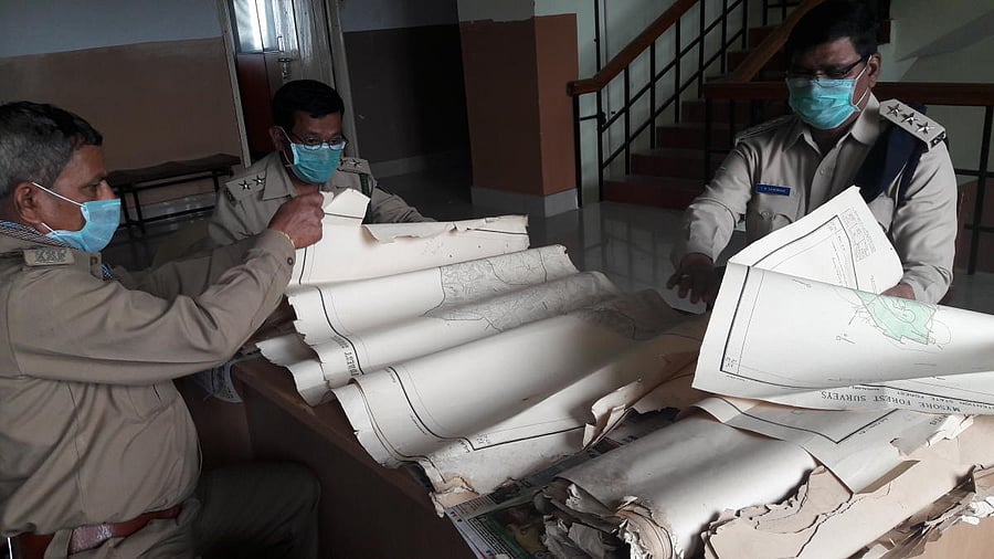 Forest department officials sift through maps at the department head office in Bengaluru.