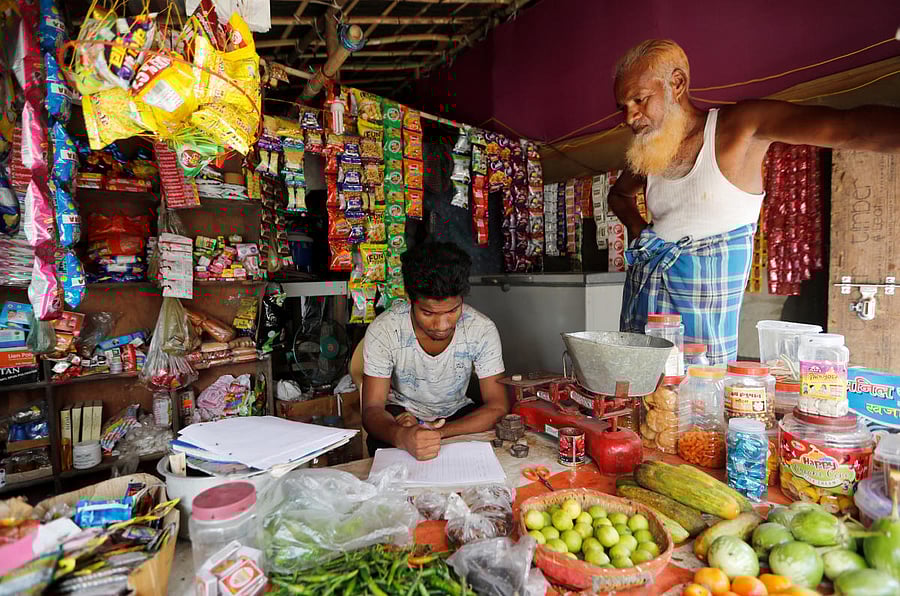 A man from the Rohingya community fills out an identification form, provided by local police, inside his shop at a camp in New Delhi, on Thursday. Reuters
