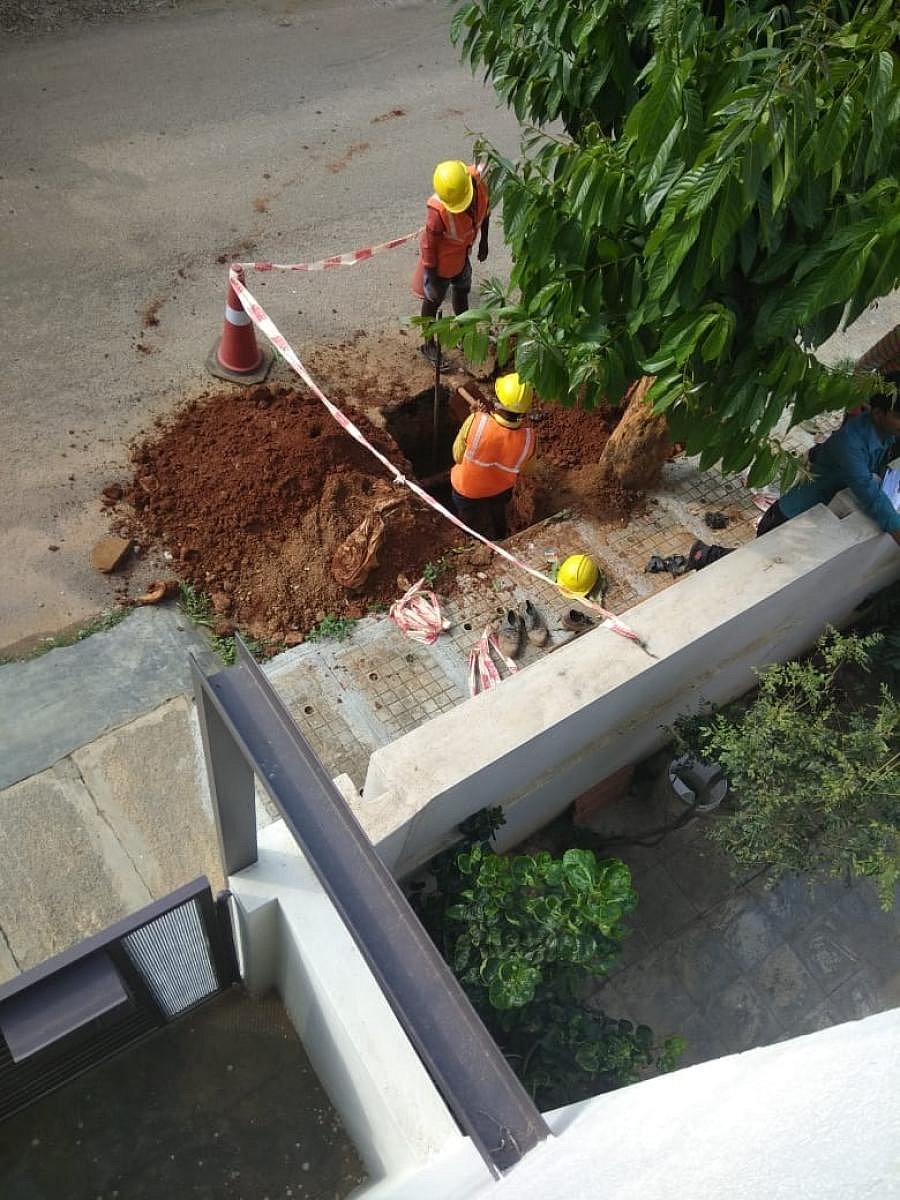 Workers digging asphalted roads to lay optical fibre cables at Sanjaynagar.