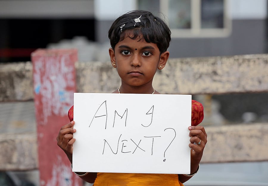 A girl holds a placard during a protest against Kathua gang-rape incident, in Kochi. Reuters File Photo