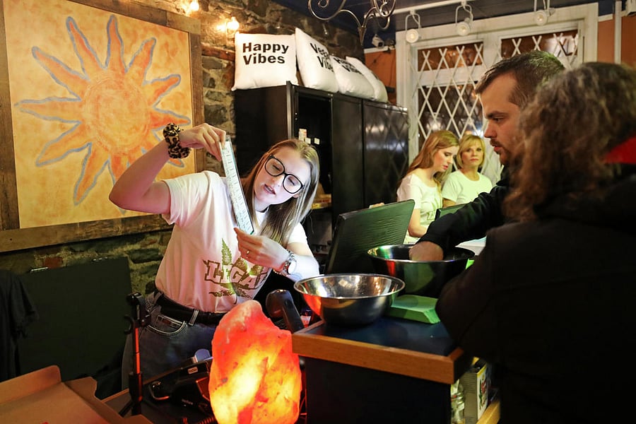 Chrissy Brun looks over a cannabis menu with customers at the Natural Vibe store after legal recreational marijuana went on sale in St John's, Newfoundland and Labrador, Canada. REUTERS Photo