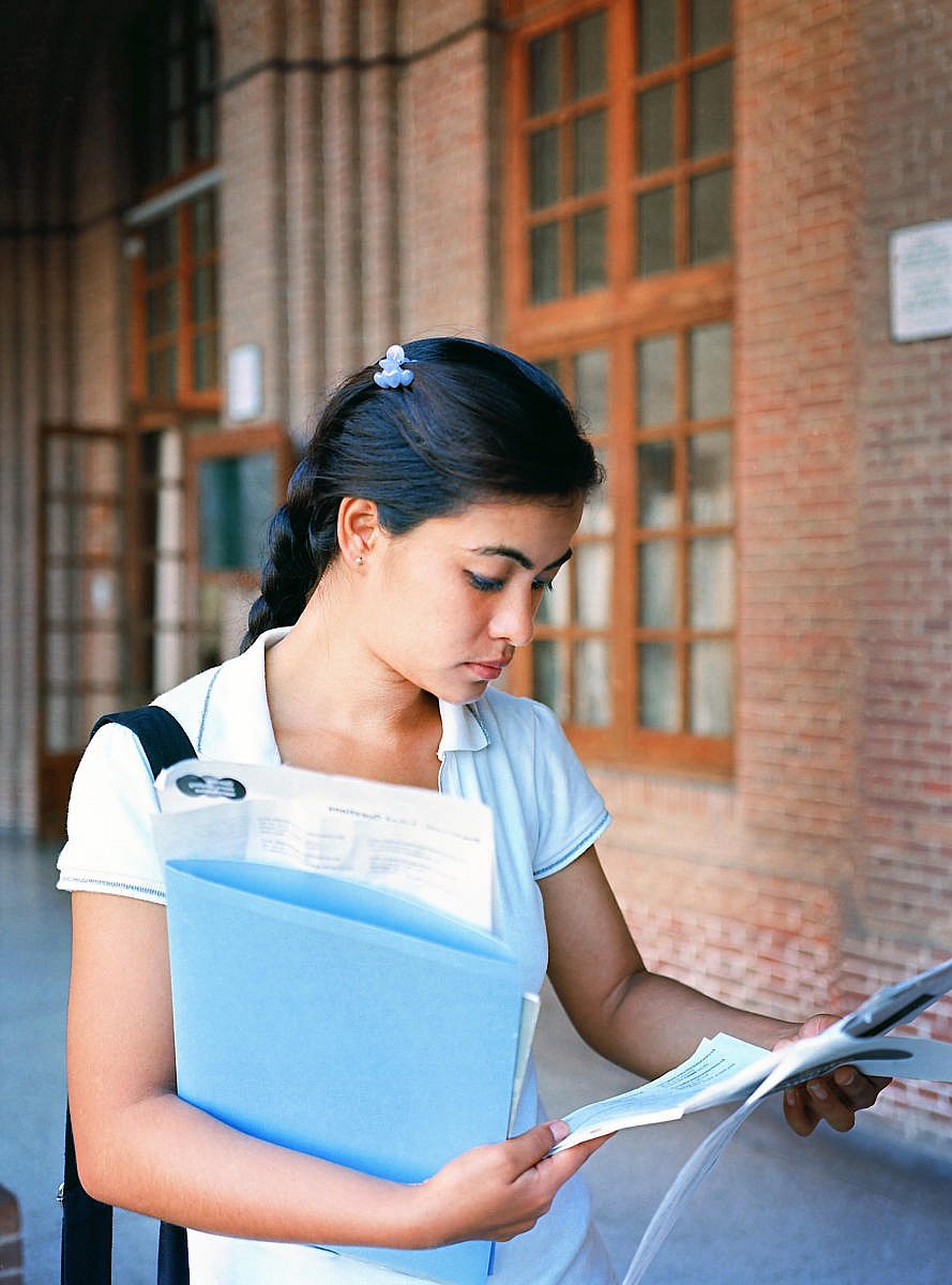 Portrait of an Indian /Asian girl / female student learning in the university corridor before an exam.